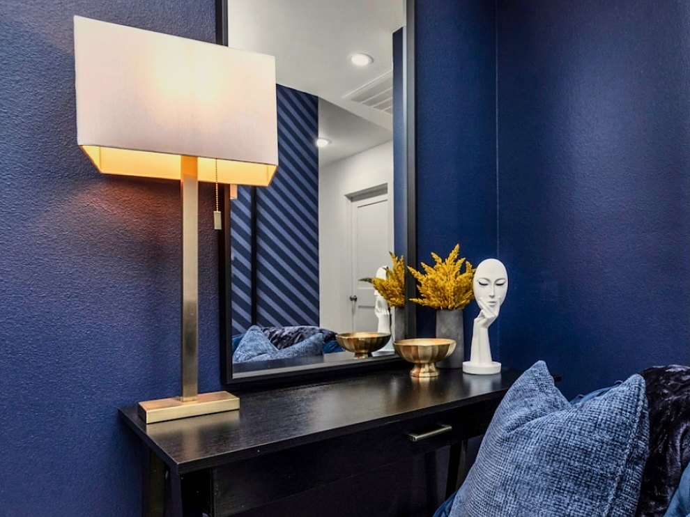 Navy console with brass lighting and sculptural objects