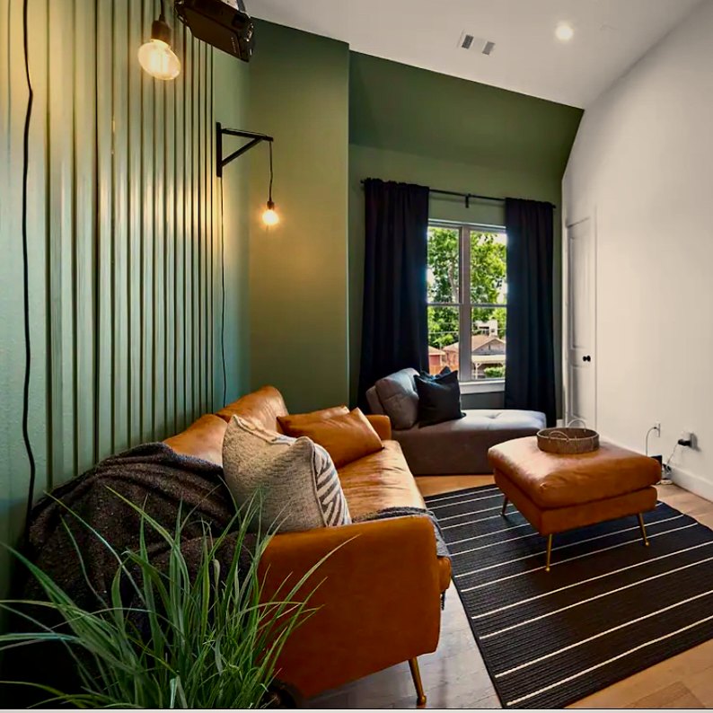 Sage walls, cognac seating and warm lighting